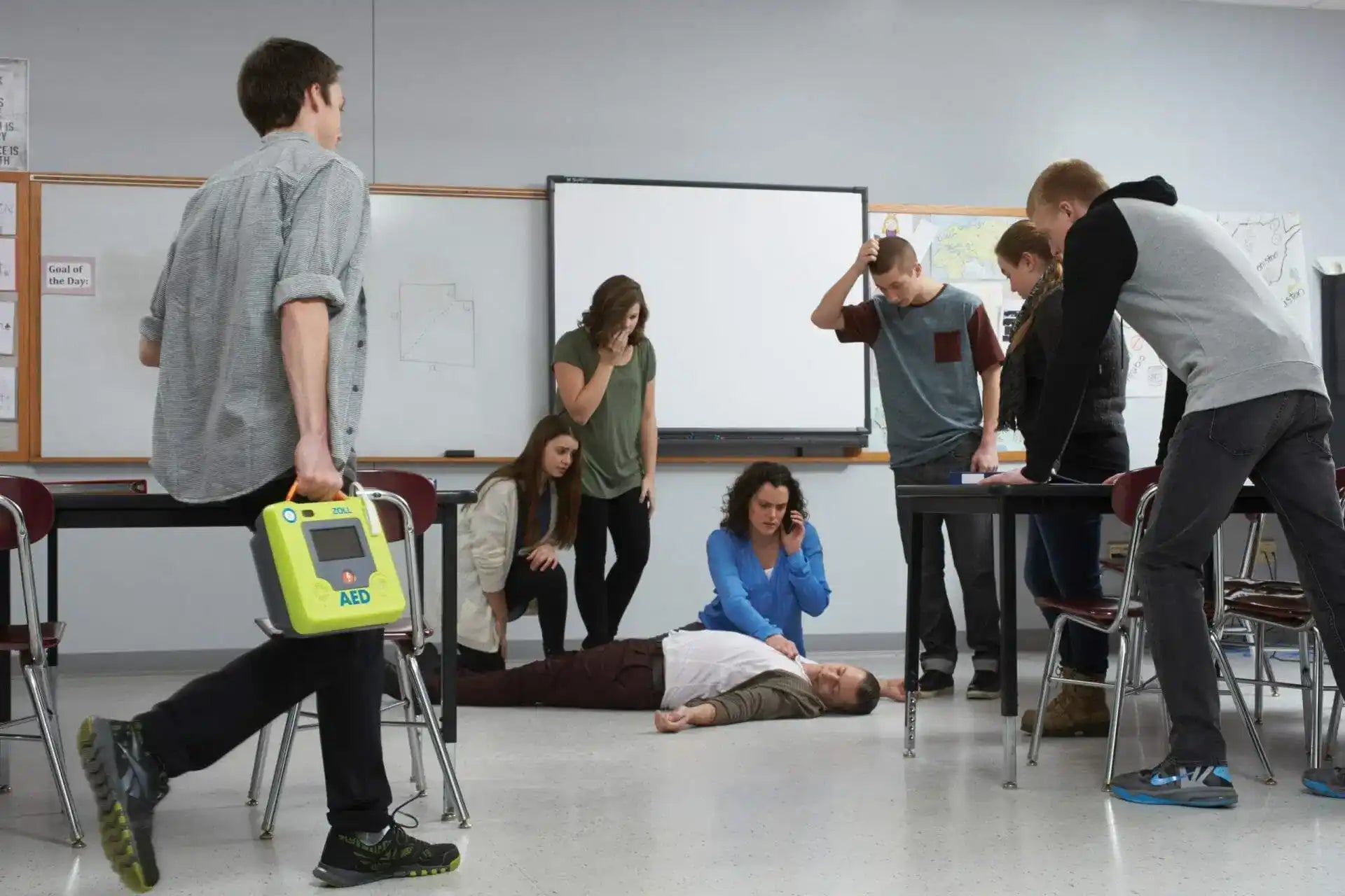 AED (Automated External Defibrillator) being carried in a classroom setting.